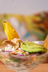 Ceviche mixto de camarones y pescado crudo, acompañado con rodajas de aguacate y chips de plátano...