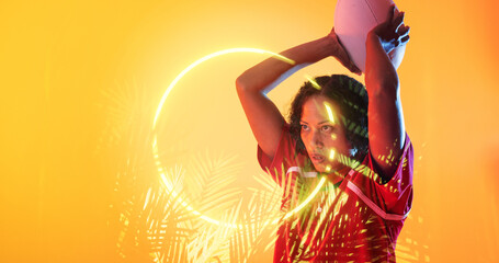 Illuminated circle and plants over biracial female rugby player throwing ball on yellow background