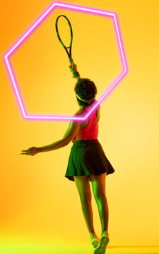 Rear view of african american tennis player with racket and illuminated hexagon on yellow background