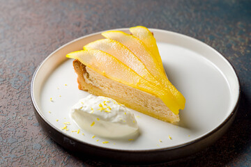 Pear pie on a plate on dark stone table