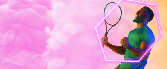 African american male player with racket screaming and shaking hands by hexagon on smoky background