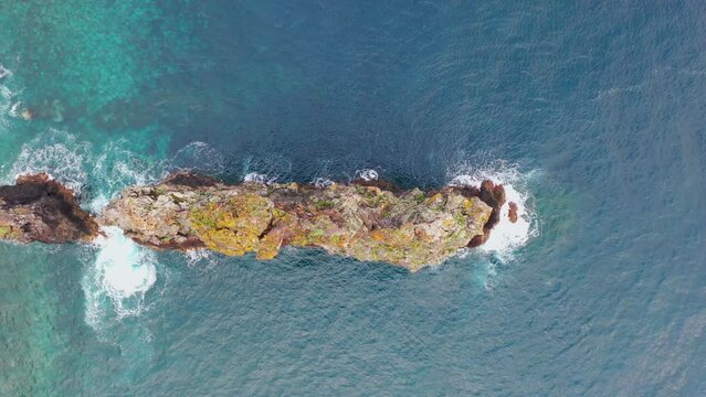 Aerial, orbit, drone footage of Ilheus da Rib costal arch, on Ribeira da Janela coast, foggy day, in Madeira, Portugal.