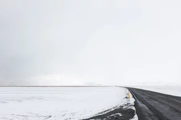 Fotobehang Road LEading Through the Frozen Snowy Landscape of Southern Iceland in Winter © Christian Unger