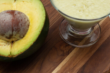 avocado smoothie and fruit on a wooden background