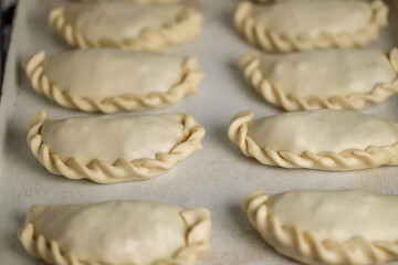 Raw argentinian empanadas on a platter.