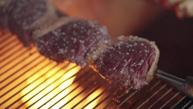Close up of fresh Picanha on a grill fire slow motion. Traditional Churrasco Brazilian Barbecue. Steakhouse
