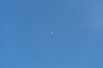 half moon in the clear sky in the afternoon