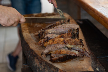 Argentinian man cutting roast meat. Traditional Argentinian roast. Barbecue.