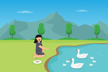 Obraz na płótnie Canvas girl feeding food to a flock of ducks in the lake while enjoying leisure time