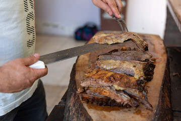 Argentinian man cutting roast meat. Traditional Argentinian roast. Barbecue.