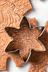 Cookie mold on dough close up. Baking ingredients for Christmas patterned cookies and gingerbread. Xmas sweet, winter holidays concept, new year treet. Horisontal orientation, top view