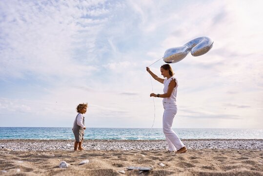 Mom and son celebrate birthday on the beach. High quality photo