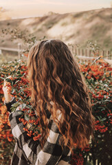 Beautiful girl with long curly hair in Autumn berries rowan