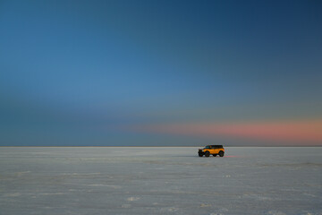 Orange Ford Bronco parked on the Bonneville Salt Flats near Wendover, Utah at twilight