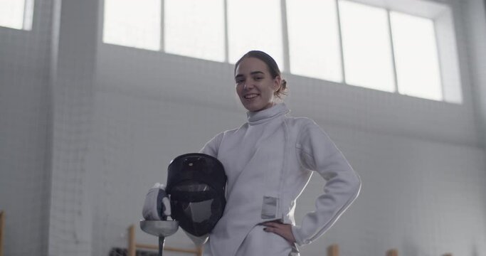 Cheerful female fencer looking at camera
