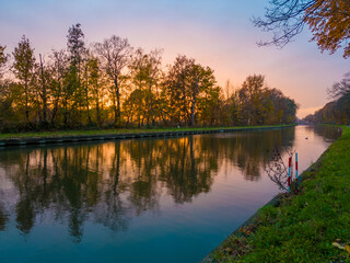 Beautiful sunset over a river with green bushes and color rich sky. High quality photo