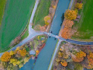 Top view of dark autumnforest landscape wallpaper art. Aerial nature scene of pine trees and road banner design. Countryside path trough coniferous wood form above. Adventure travel background. High
