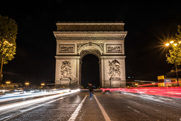 Fototapeta na wymiar Nightly traffic on the Champs-Elysees, Arc de Triomph in the background