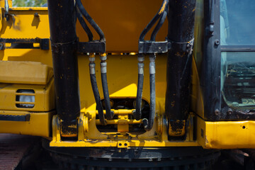 Detalle close up artistico de máquina retroexcavadora, color amarillo en construcción y campo de tierra.