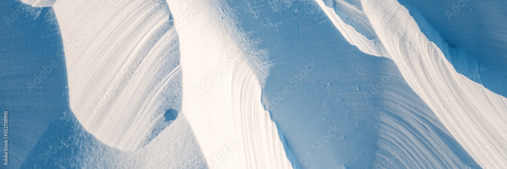 Wall mural snow texture. wind sculpted patterns on snow surface. wind in the tundra and in the mountains on the