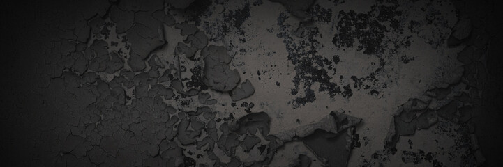 Dark wide panoramic background. Peeling paint on a concrete wall. Dark grunge texture of old cracked flaking paint. Weathered rough painted surface. Patterns of cracks. Darkness background for design.