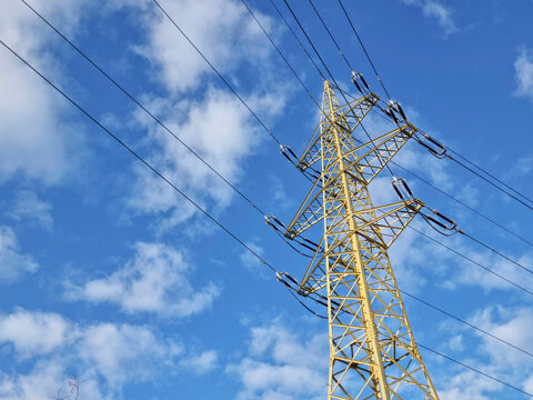 High voltage electric pole and power lines, high voltage electric transmission tower and blue cloudy sky