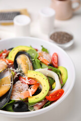 Bowl of delicious salad with seafood on white table, closeup