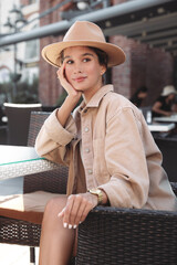 Portrait of happy young woman in outdoor cafe