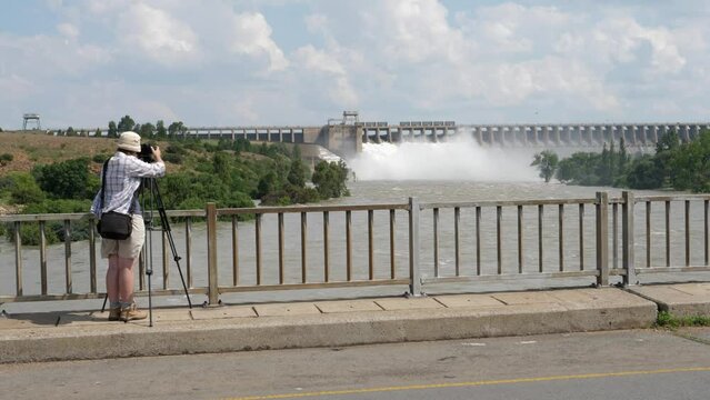 Photographer on bridge shoots Vaal River Dam releasing flood water