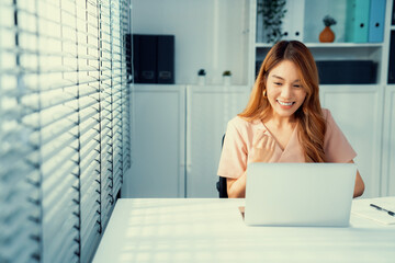 A young female employee receives a promotion, good news or finished her task and overjoyed for...