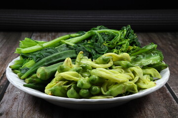 Pile of boiled mixed vegetable serving on the plate. Famous side dish menu in Asia restaurant. 