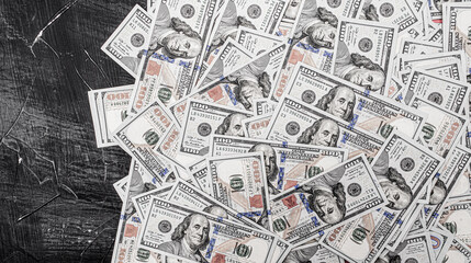 Fototapeta na wymiar American dollars on a black cement background. One hundred dollar bills.
