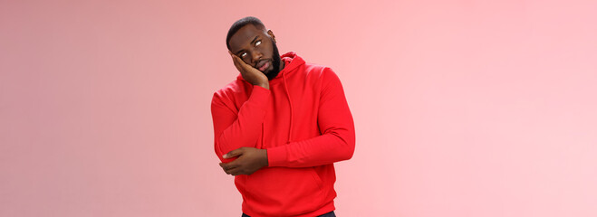 Annoyed bored funny attractive african american guy in red hoodie roll eyelids facepalm head lean...