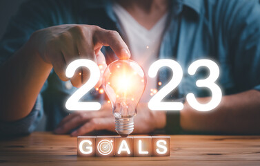 2023 lightbulb with glowing light sparkling effect. Concept of 2023 goals, ideas, target, business...