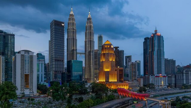 Wide angle cityscape time lapse with busy expressway against the Kuala Lumpur city skyline during sunrise until morning with colourful city lights from afar. Prores 4KUHD