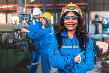 Young people worker in protective uniform operating machine at factory Industrial.People working in industry.Portrait of Female Engineer looking camera at work place.