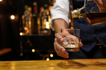 Bartender pouring Whiskey, on  bar