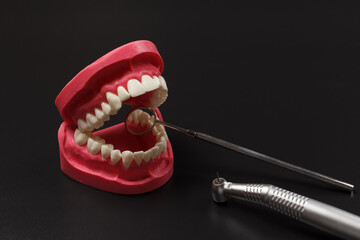 Layout of the human jaw with metal mirror and head of high-speed dental handpiece.