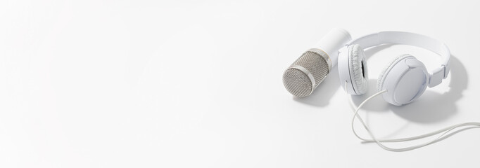 White headphones and microphone for sound recording. banner. on a white background
