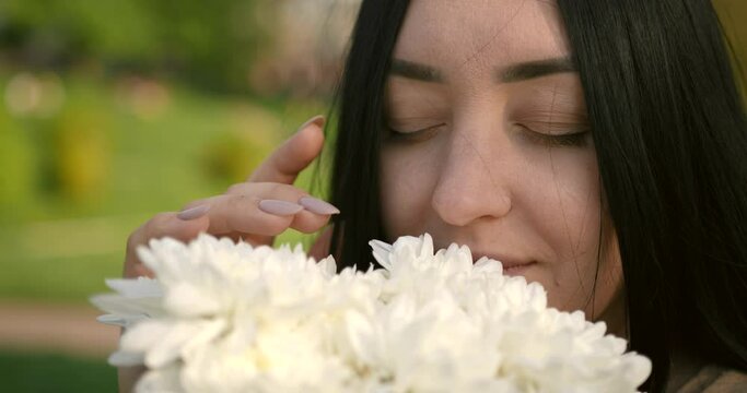 Closeup view of young woman holding white flowers