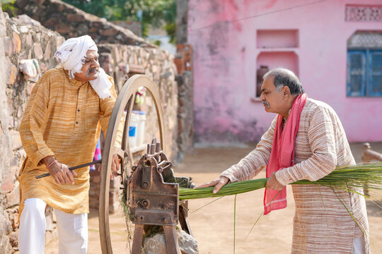 Two Old Indian Farmers Using Grass Cutting Machine At Home