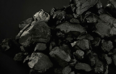 Węgiel kamienny z bliska na czarnym tle.