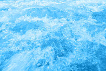 Defocus blurred transparent blue colored clear calm water surface texture with splashes and bubbles. Trendy abstract nature background. Water waves in sunlight with copy space. Blue watercolor shining