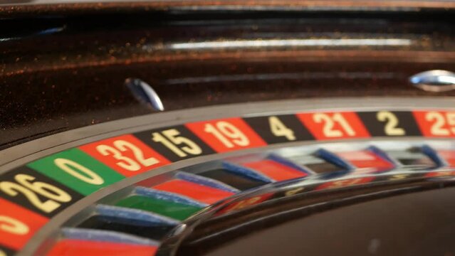Ball on wooden french roulette table in casino. Wheel spinning, turning or rotating. Odd and even numbers, black, red and zero sectors. Bets in game of chance. Money playing, gambling or risky betting