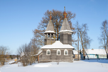 View of the ancient wooden chapel of St. George the Victorious on a sunny February day. Niz village, Kargopol district. Arkhangelsk region, Russia