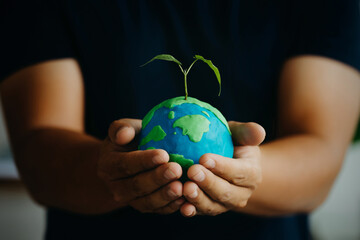 Earth and plant were held in human hands. Earth day. Energy saving concept, ecology, and...