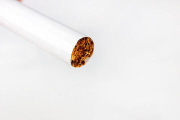 One cigarette on white background close up. Smoking addiction and nicotine dependence concept.