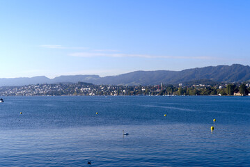 Scenic view over Lake Z&uuml;rich seen from City of Z&uuml;rich with pier and Swiss Alps in the background on a sunny late summer day. Photo taken September 22, 2022, Zurich, Switzerland.