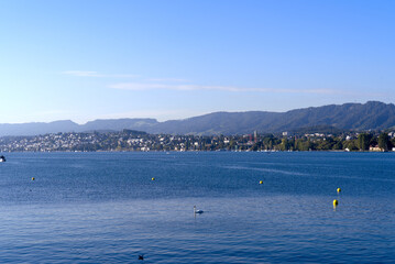 Scenic view over Lake Zürich seen from City of Zürich with pier and Swiss Alps in the background on a sunny late summer day. Photo taken September 22, 2022, Zurich, Switzerland.