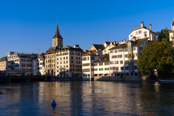 Fototapeta premium Beautiful cityscape of the old town of Zürich with Limmat River in the foreground with historic houses and bridge on a sunny late summer morning. Photo taken September 22nd, 2022, Zurich, Switzerland.